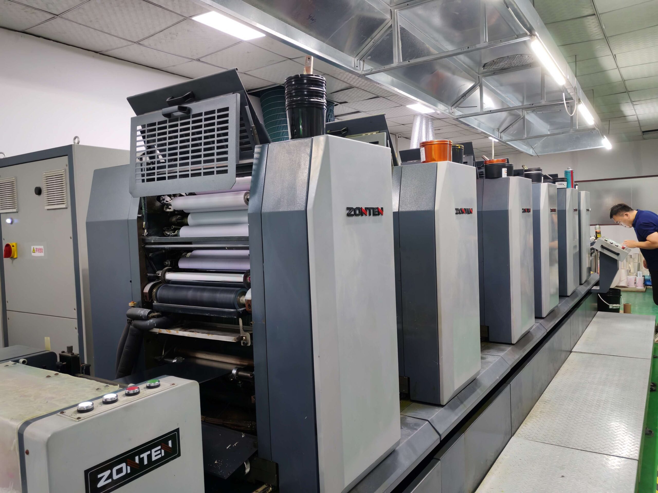 Label printing factory with modern machines and staff working on custom labels